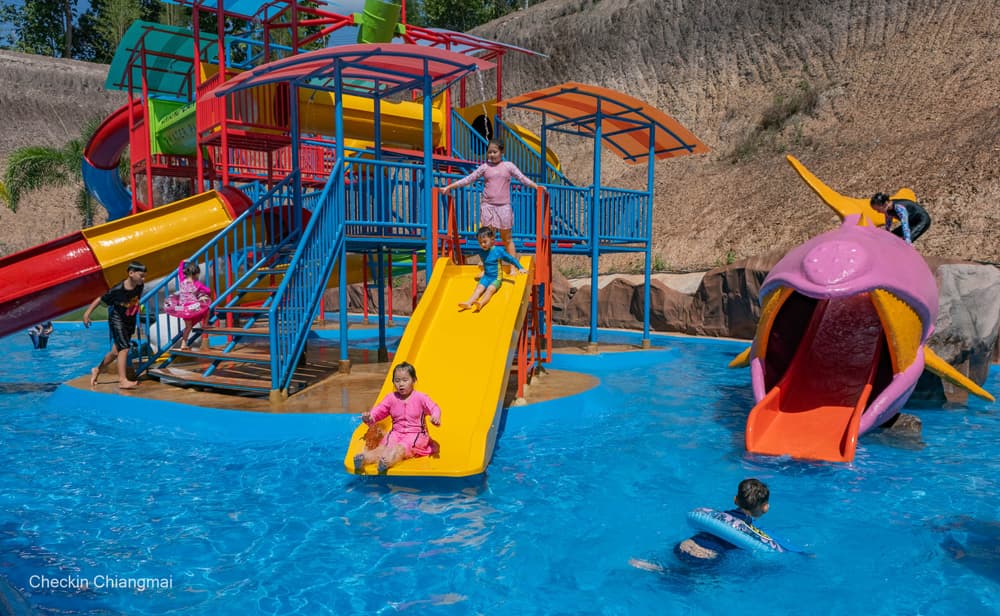 Children sliding into bright blue pools at the pirate-themed kids zone