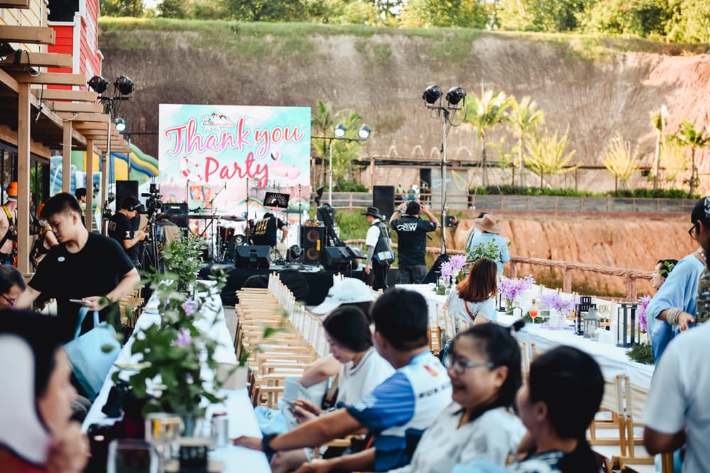 Guests dining at long tables on the canyon edge at golden hour
